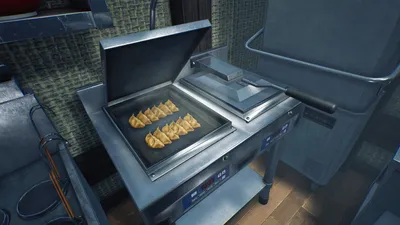 Gyoza browning on an open griddle in the restaurant kitchen.